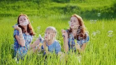 三个姐<strong>妹</strong>在一片绿色的草地上玩<strong>肥</strong>皂泡。 一起玩，快乐的童年